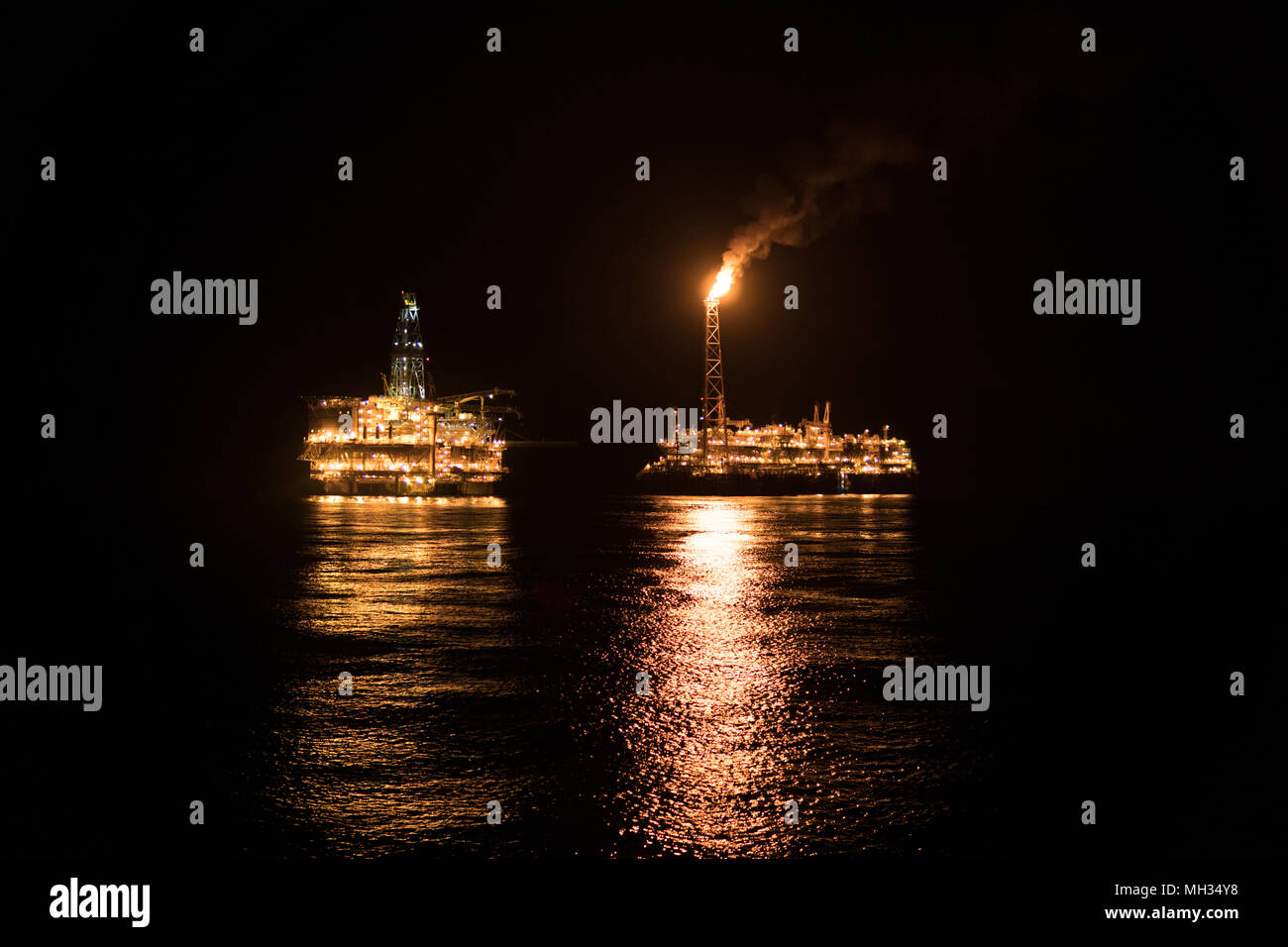 FPSO tanker vessel near Oil Rig at night. Offshore oil and gas industry ...