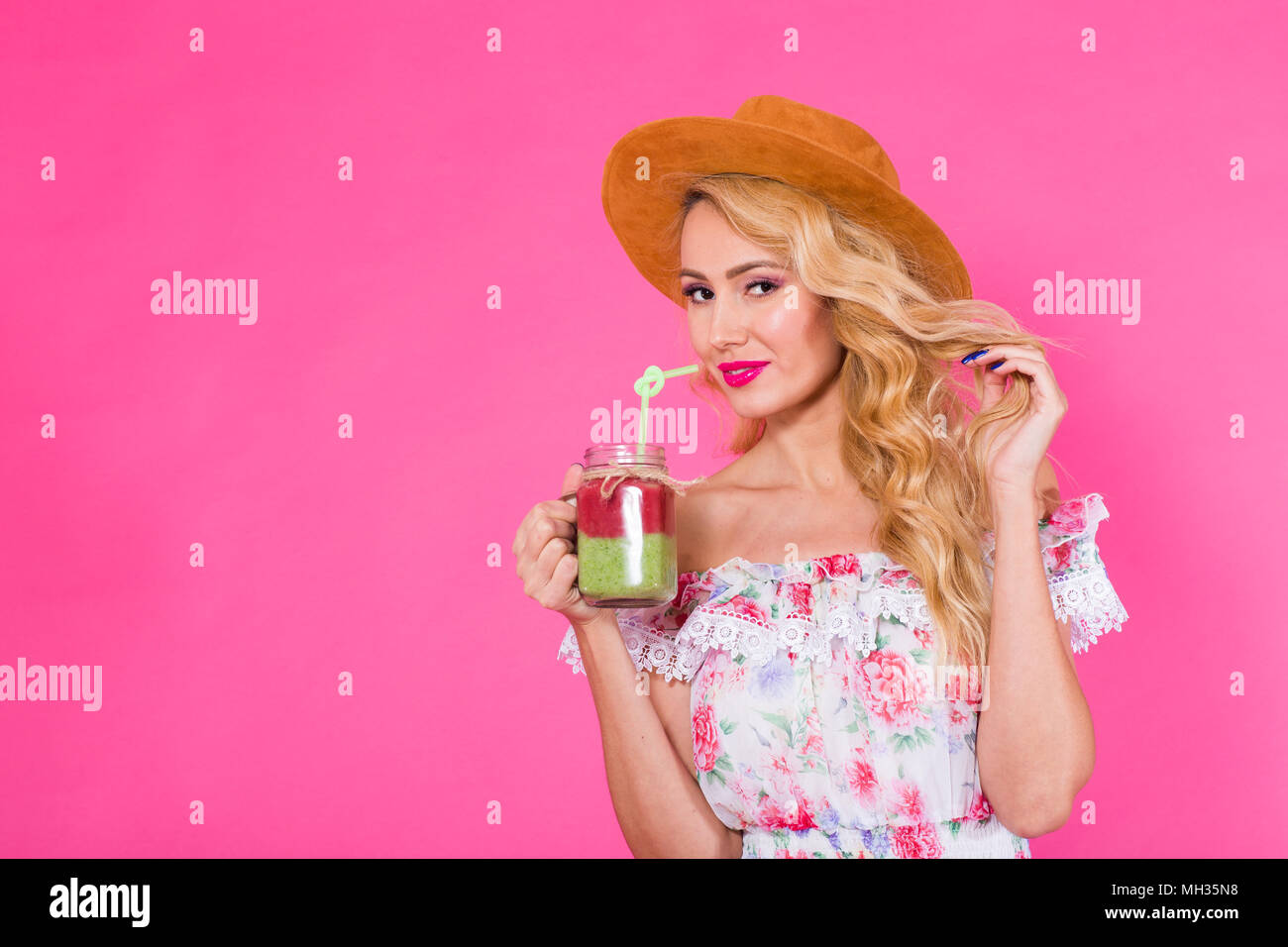 Cherry smoothie in a big glass cup with two straws in woman's hands,  isolated on white background. Lady with a drink Stock Photo - Alamy