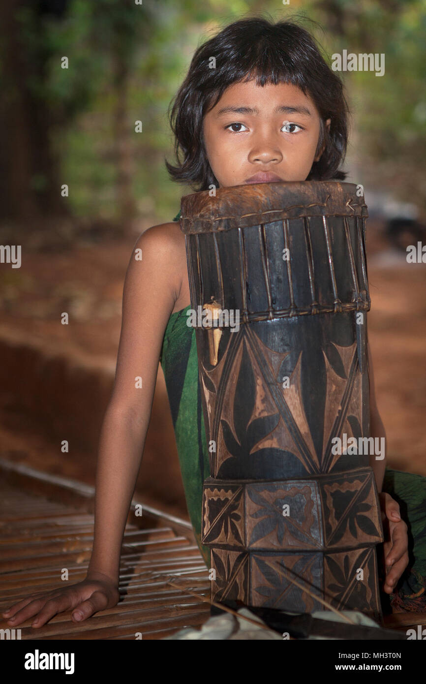 Portrait of a Palaw'an girl resting her head on a Philippine drum called a 'Dabakan'. Taken at the Eco Butterfly Garden and Tribal Village in Puerto P Stock Photo