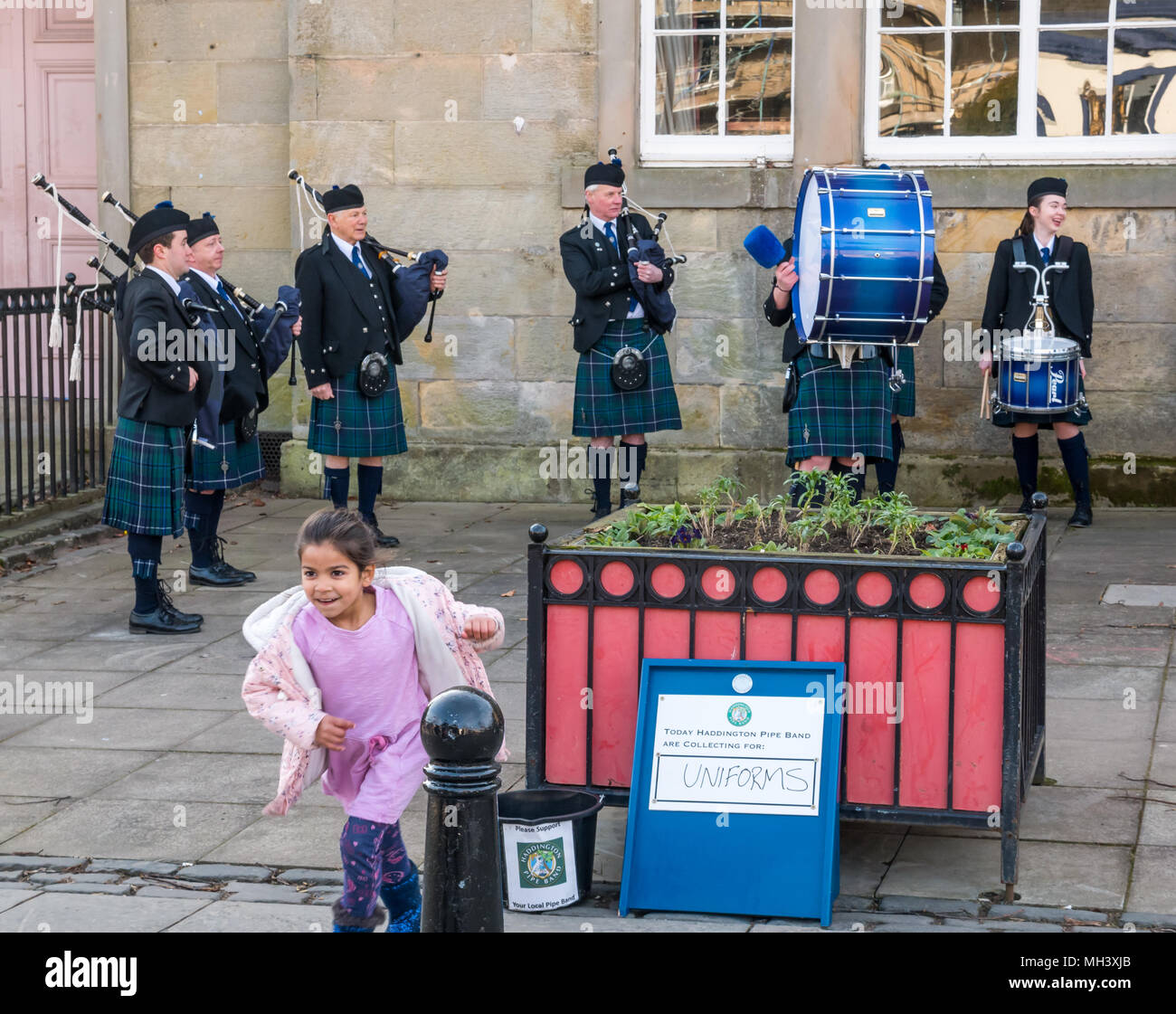 Young child giving donation to Haddington Pipe Band, Corn Exchange, Place d'Aubigny, Court Street, East Lothian, Scotland, UK Stock Photo