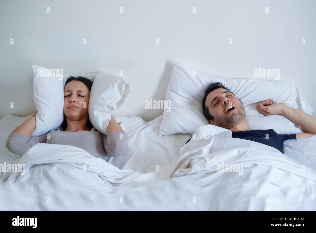 Woman can't sleep because her boyfriend is snoring loudly Stock Photo