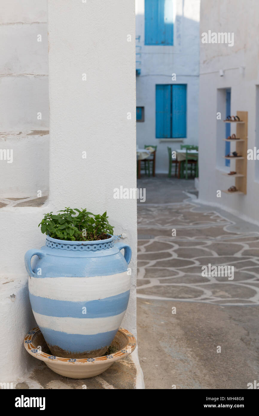 blue and white striped pot with plant in village center on Milos island, Greece Stock Photo