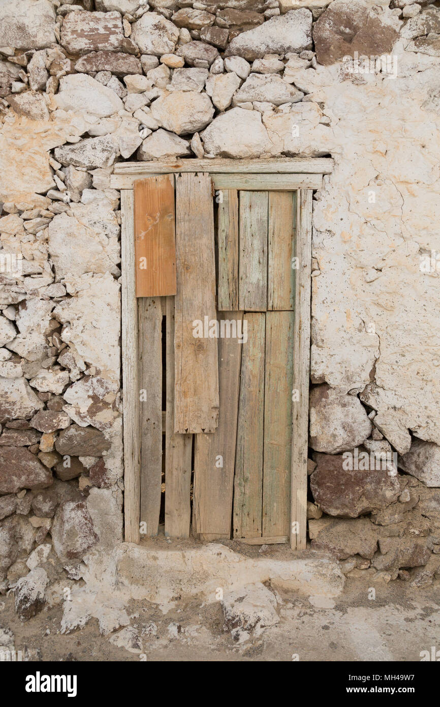 old crumbling rock house with wooden doors Stock Photo
