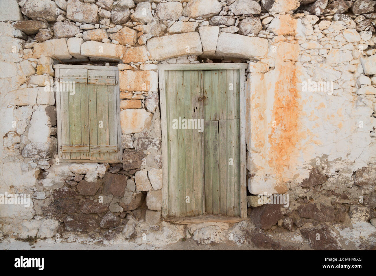old crumbling rock house with wooden doors Stock Photo
