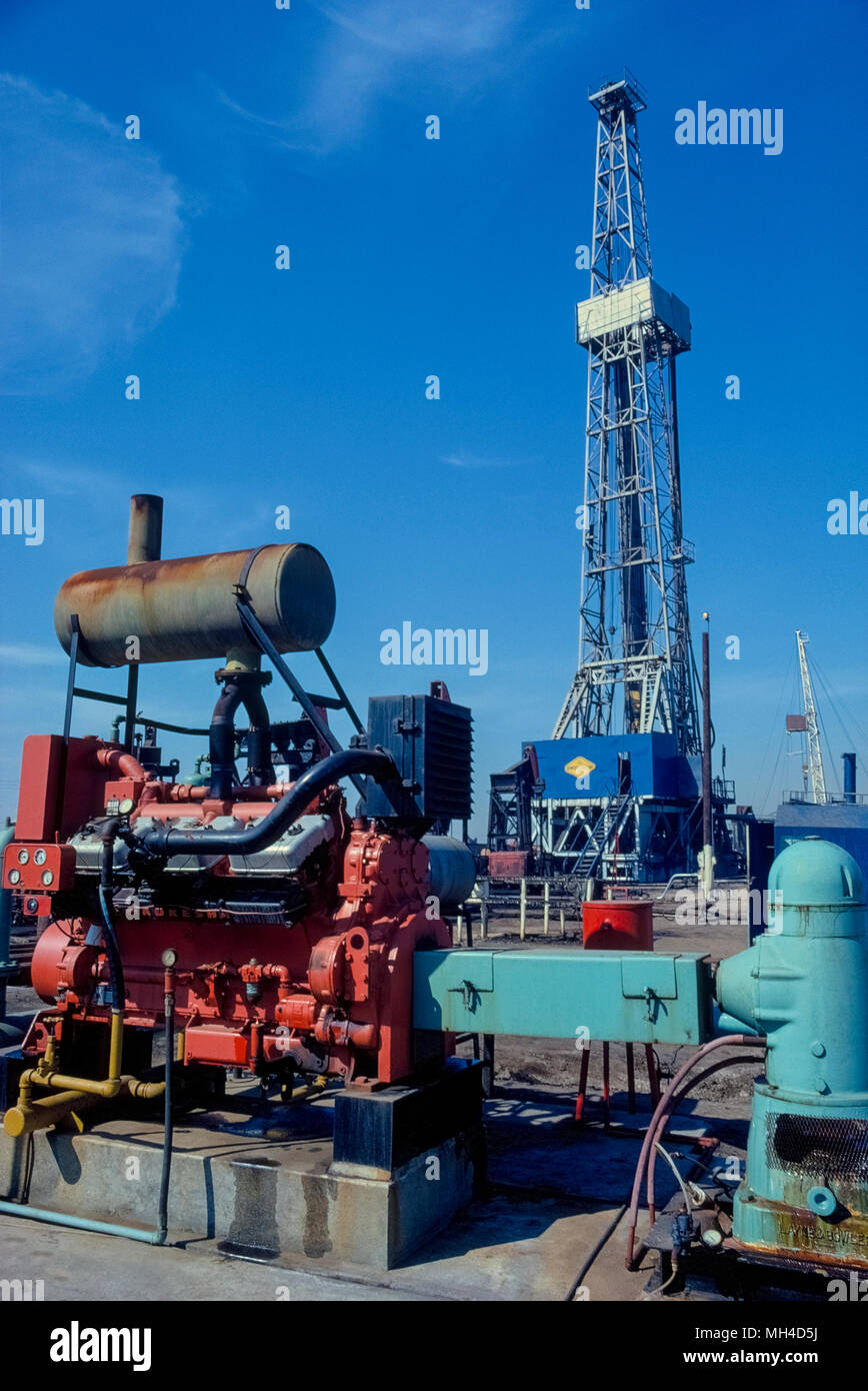 A towering oil derrick and pumping equipment for extracting petroleum from underground is seen in 1982 in Huntington Beach, California, USA, where 'black gold' was first struck in 1920 and began an oil boom in Southern California. In recent years, many of the pumps and oil-drilling derricks in this coastal city have been replaced by housing developments. Historical photograph. Stock Photo