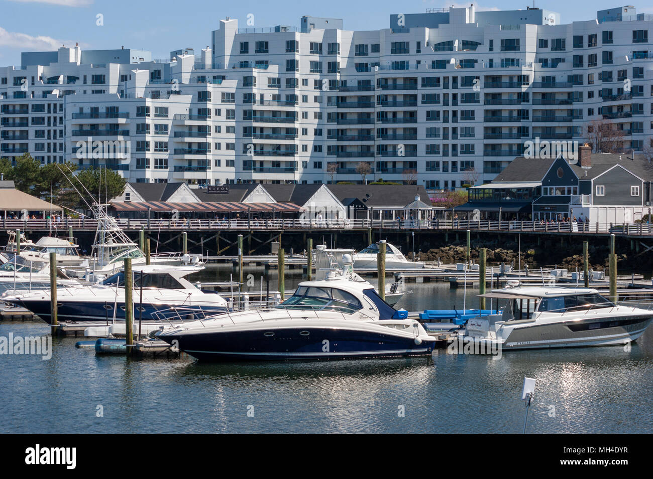 Yachts moored at Marina Bay docks, in front of a waterfront boardwalk