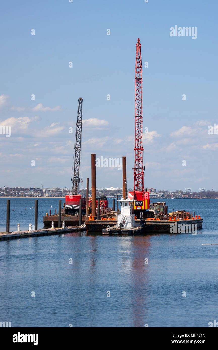 Marine construction barges with cranes for pile driving. Marina Bay, Quincy, MA. Stock Photo