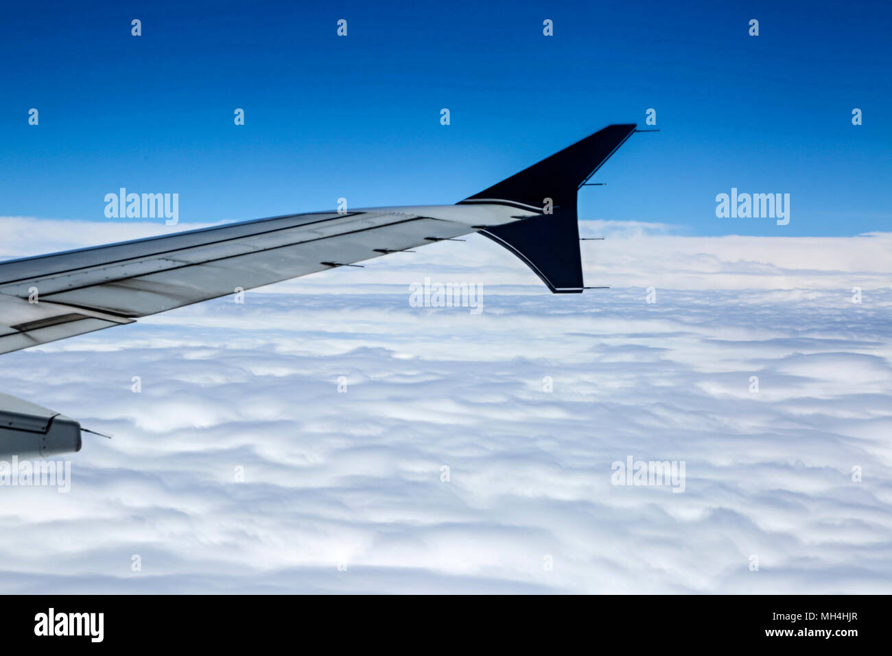 A Commercial Plane in Flight Over the Clouds Stock Photo