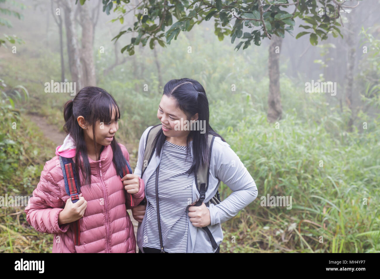 Asia girl Mother and daughter backpack behind go hiking or climbing in Nature Mountain. Stock Photo