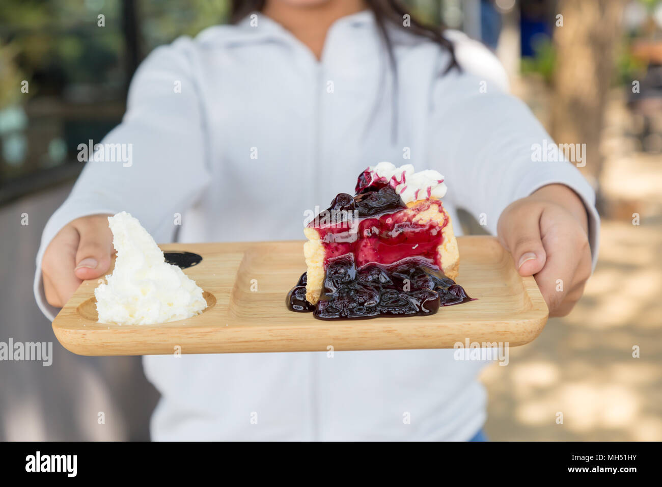 Asia teenage girl filed the blueberry cheesecake comes in front. Stock Photo