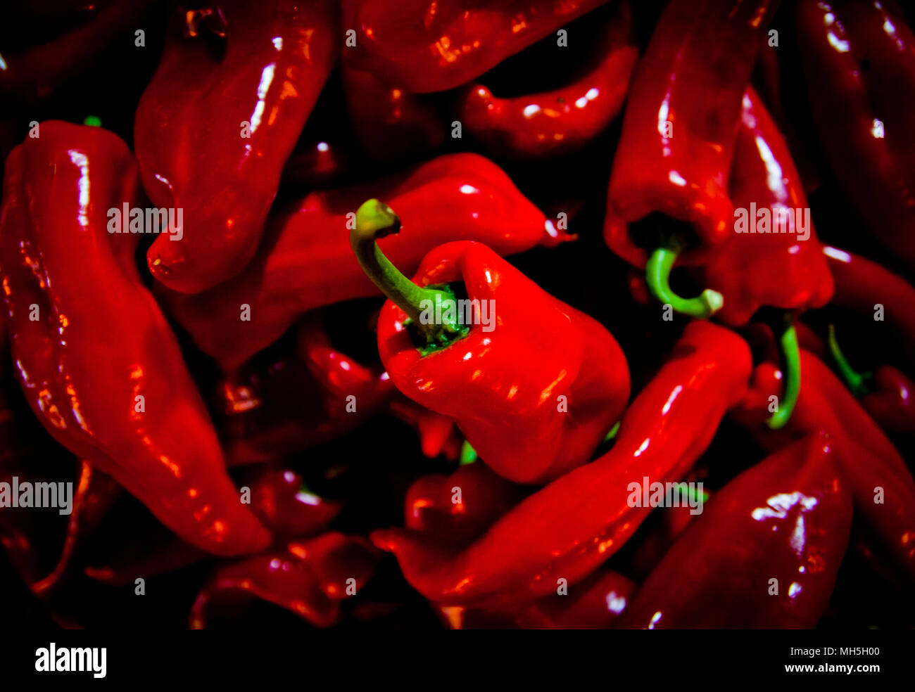 Piles of fresh red peppers for sale at a market stall during the night ...