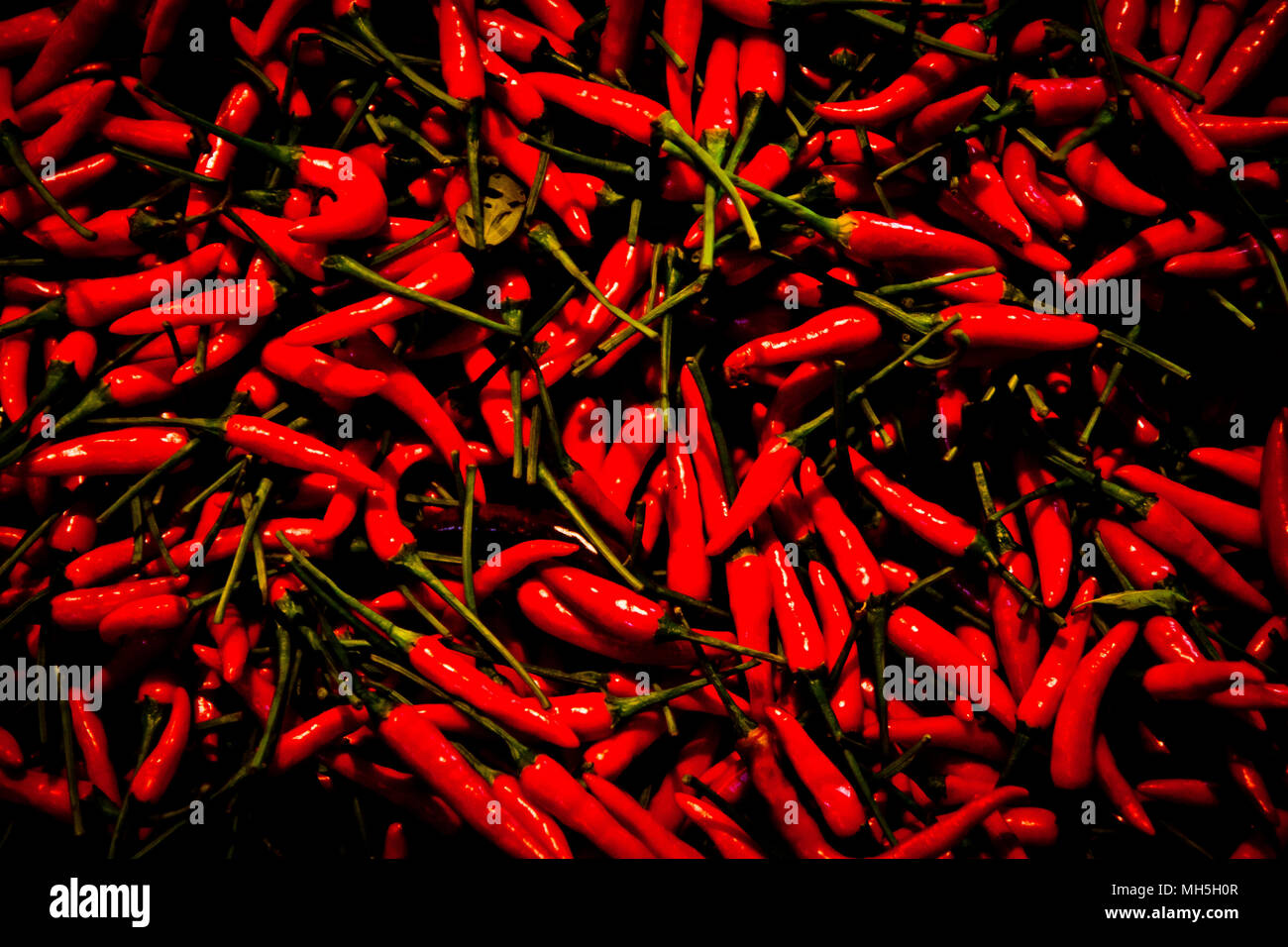 Piles of fresh red chilli peppers for sale at a market stall during the ...