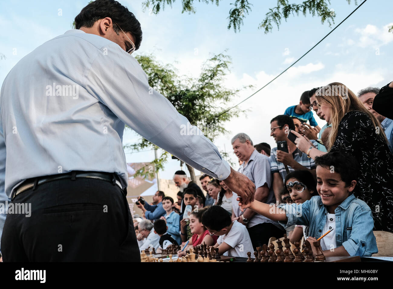 Jerusalem, Israel. 30th April, 2018. VISWANATHAN VISHY ANAND, 49, Indian chess grandmaster, plays a game of chess against YEHONATAN AZULAI, 8, and against dozens of Israeli youth champions simultaneously at the Jaffa Gate in the framework of Israel's 70th Independence Day celebrations. Credit: Nir Alon/Alamy Live News Stock Photo