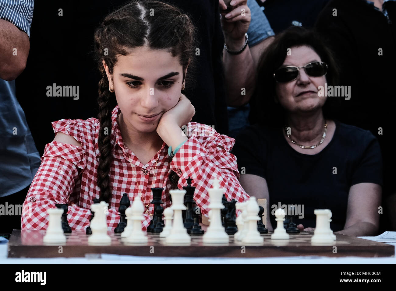 Jerusalem, Israel. 30th April, 2018. HUDA KASSEM, 13, from the Arab town Tira, studies her chess board as she plays against Anatoly Yevgenyevich Karpov (R), 66, Russian chess grandmaster, as he plays against dozens of Israeli youth champions simultaneously at the Jaffa Gate in the framework of Israel's 70th Independence Day celebrations. Credit: Nir Alon/Alamy Live News Stock Photo