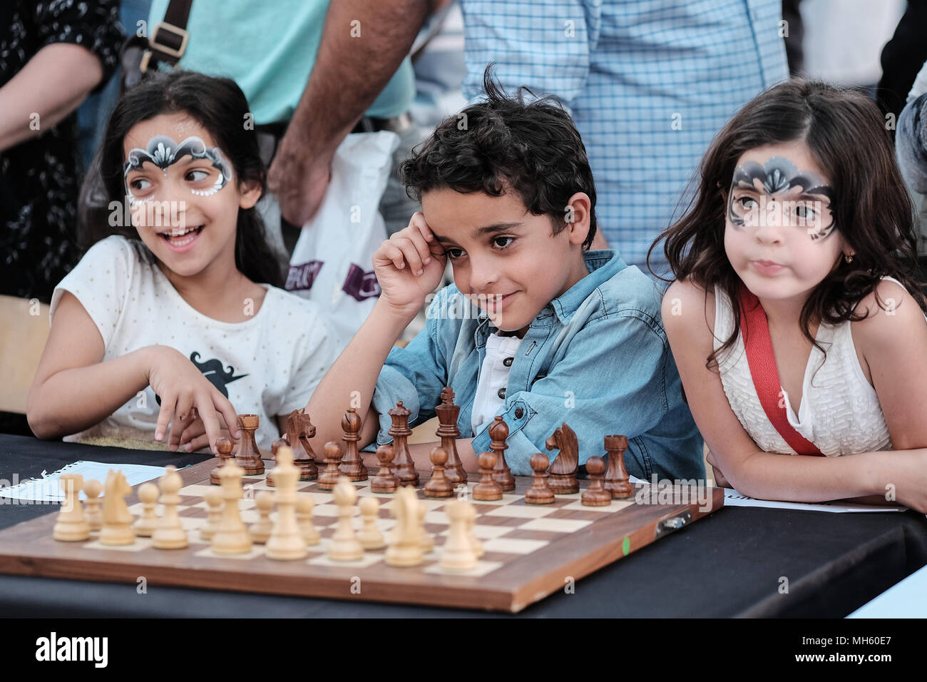 Jerusalem, Israel. 30th April, 2018. YEHONATAN AZULAI (C), 8, awaits the opening of a chess game against Viswanathan 'Vishy' Anand, 49, Indian chess grandmaster, who is about to play chess against dozens of Israeli youth champions simultaneously at the Jaffa Gate in the framework of Israel's 70th Independence Day celebrations. Credit: Nir Alon/Alamy Live News Stock Photo