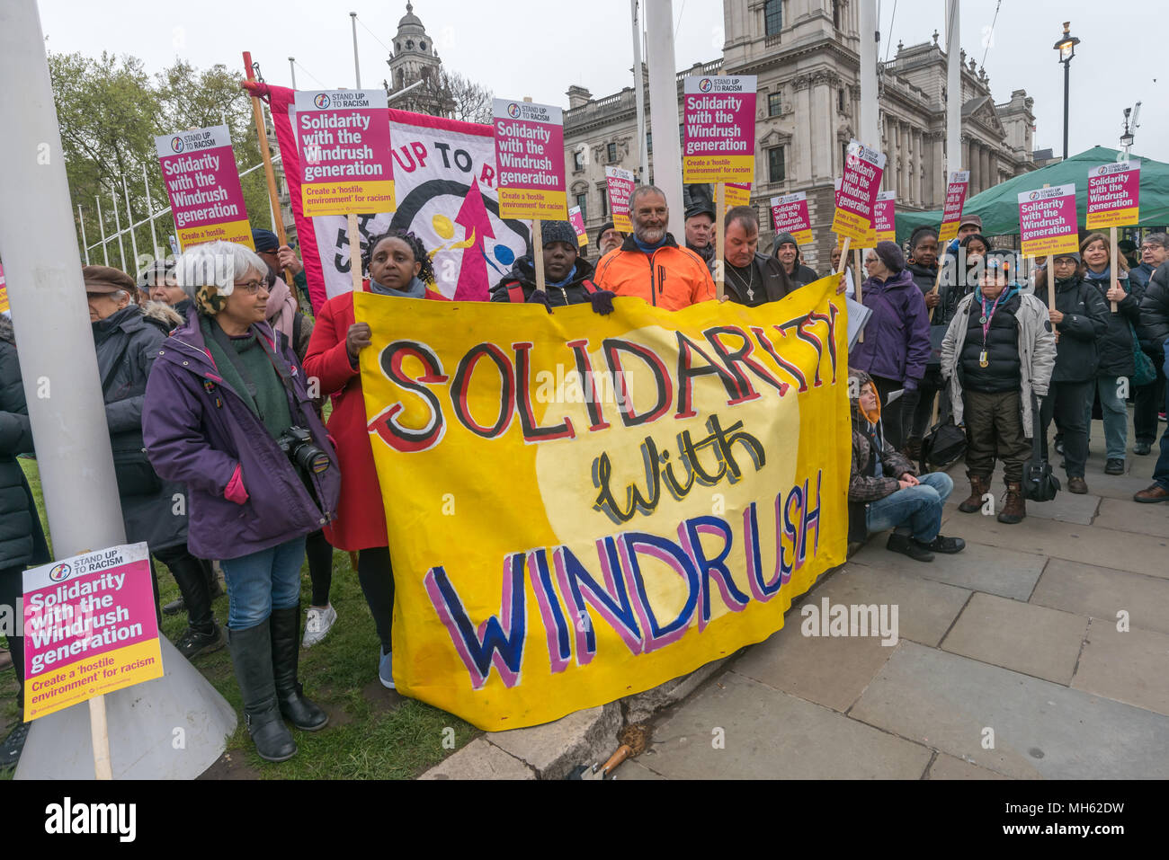 London, UK. 30th April 2018.  People hold the 'Solidarity With Windrush' banner at the protest in support of the petition calling for an end to the deportations of migrants in the 'Windrush generation' who arrived in Britain between 1948 and 1971. It calls on the government to change the burden of proof which means they are now required to prove their right to remain, and to provide compensation for any loss and hurt.. re for many years, paying taxes and raising famil Credit: Peter Marshall/Alamy Live News Stock Photo