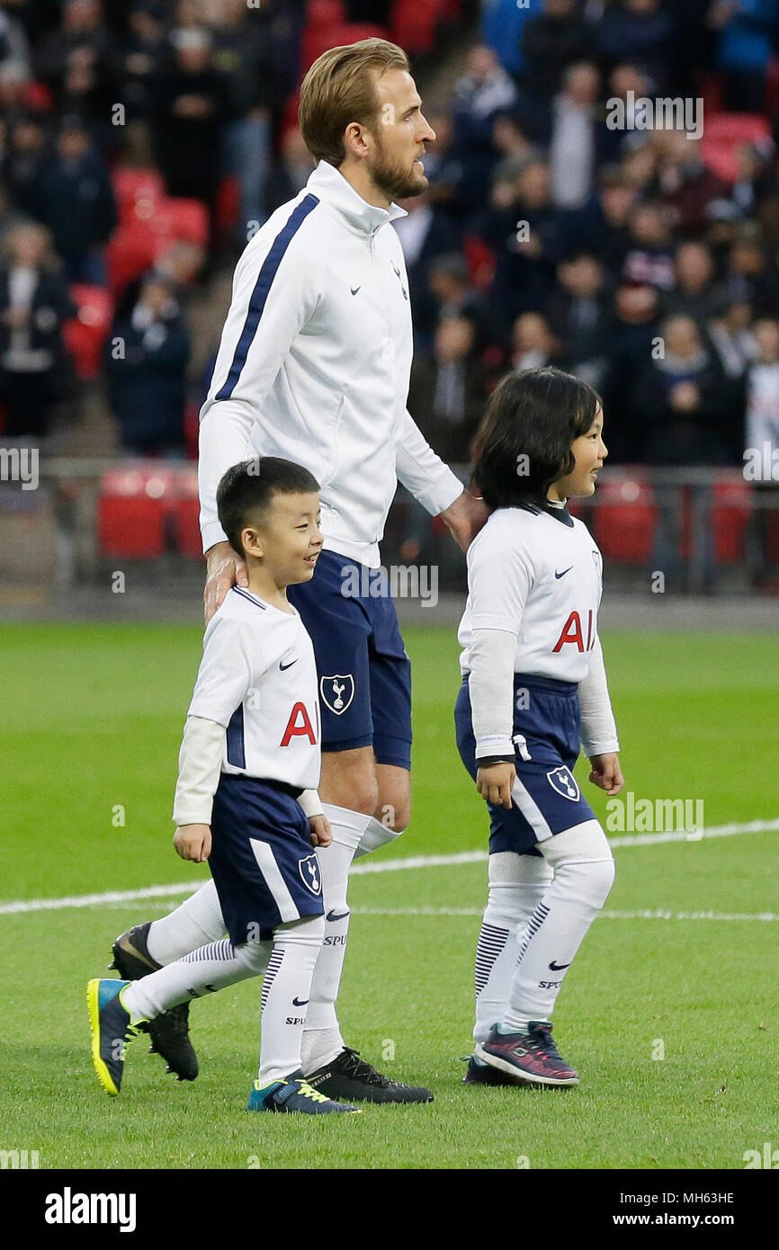 London, Britain. 30th Apr, 2018. Tottenham Hotspur's Harry Kane walks into the pitch with ballkids from China before the Premier League soccer match between Tottenham Hotspur and Watford at Wembley Stadium in London, Britain, on April 30, 2018. Tottenham Hotspur won 2-0. Credit: Tim Ireland/Xinhua/Alamy Live News Stock Photo
