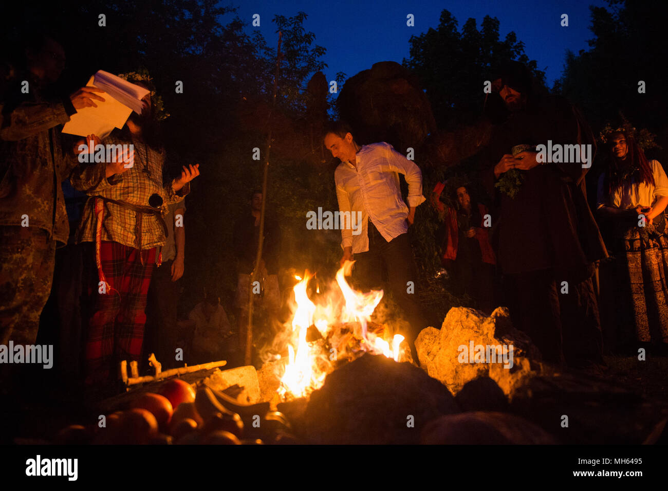 Participants pray during the Beltane feast of Fire next to Krakau Mound in Krakow. The Beltane Fire Festival is an annual participatory arts event held on the night 30 April to mark the beginning of the Summer. Stock Photo