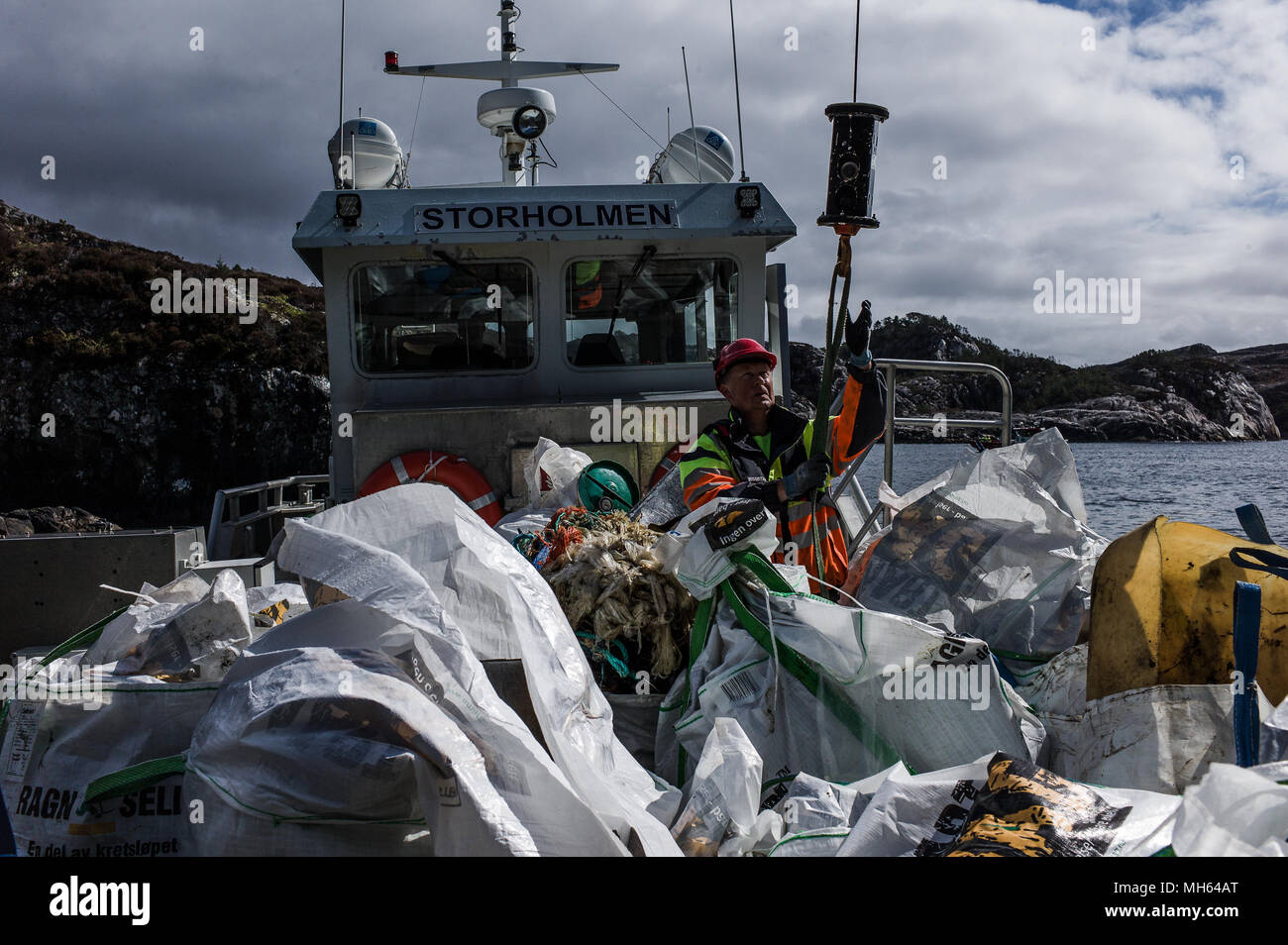 Huge amounts of marine litter are transported on a boat during a beach clean off the coast of Norway. Around 150 volunteers from 12 countries attended the Plastic Whale Heritage beach cleaning event in Norway.  The event took place in 6 bays on the islands off the coast of Sotra, coming off the back of the 1 year anniversary of the Cuviers Beaked whale which was found to have several kilos of plastic inside it's stomach after it was euthanized and subsequently autopsied.  The Plastic Whale Heritage is a group of around 30 organisations that have come together to raise the profile of the growin Stock Photo