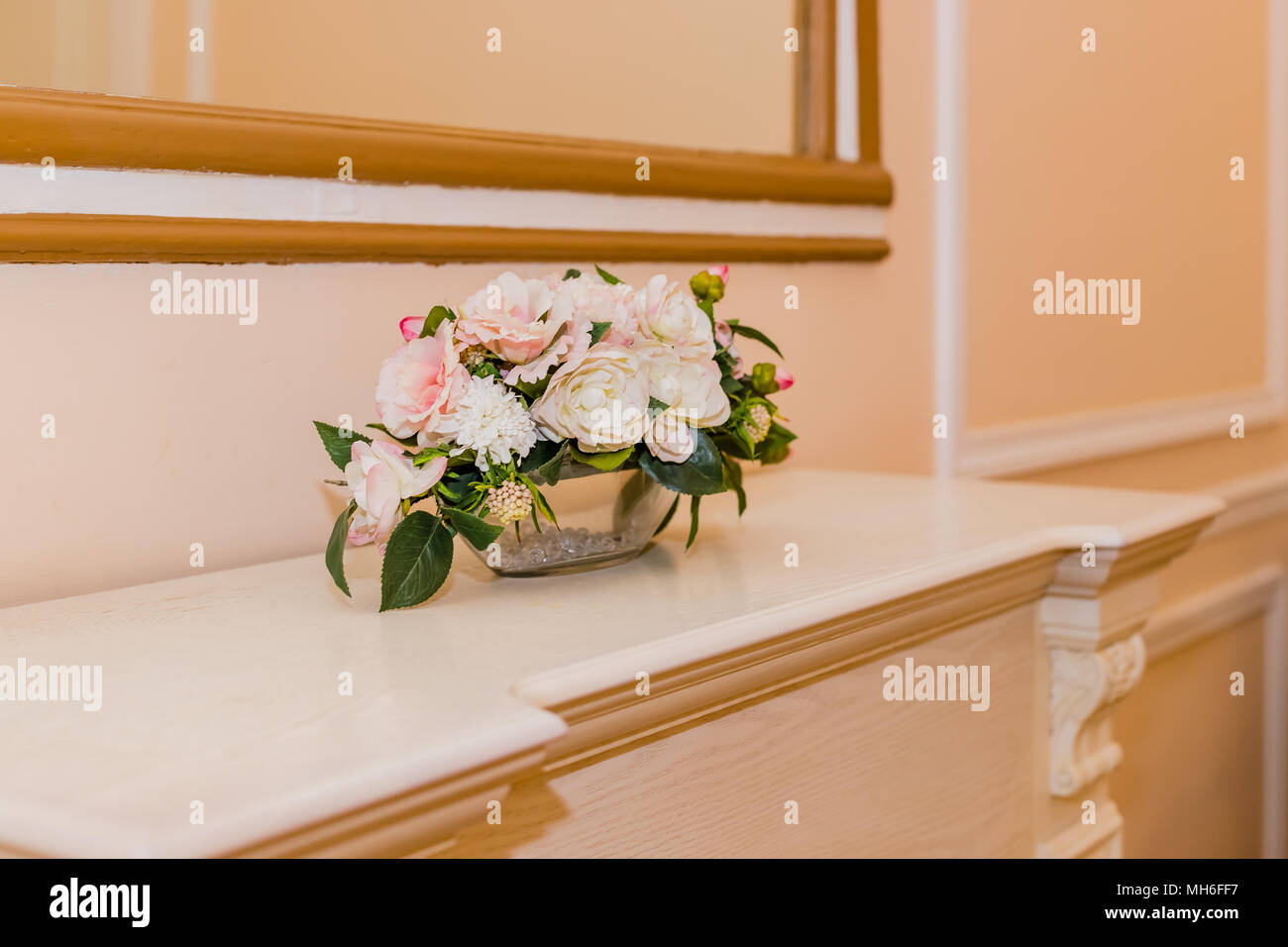 Beautiful flower wedding bouquet of white roses, pink roses, with sprigs of eucalyptus on white shelf ,decoration lying on fireplace. Toned image Stock Photo