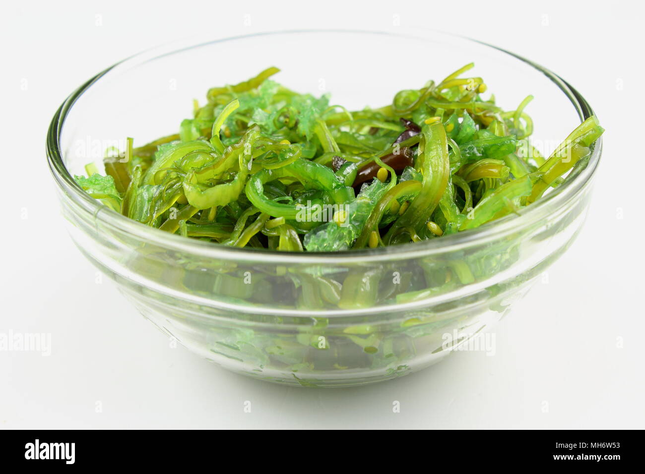 wakame salad with sesame in a small glass bowl isolated on a white background Stock Photo