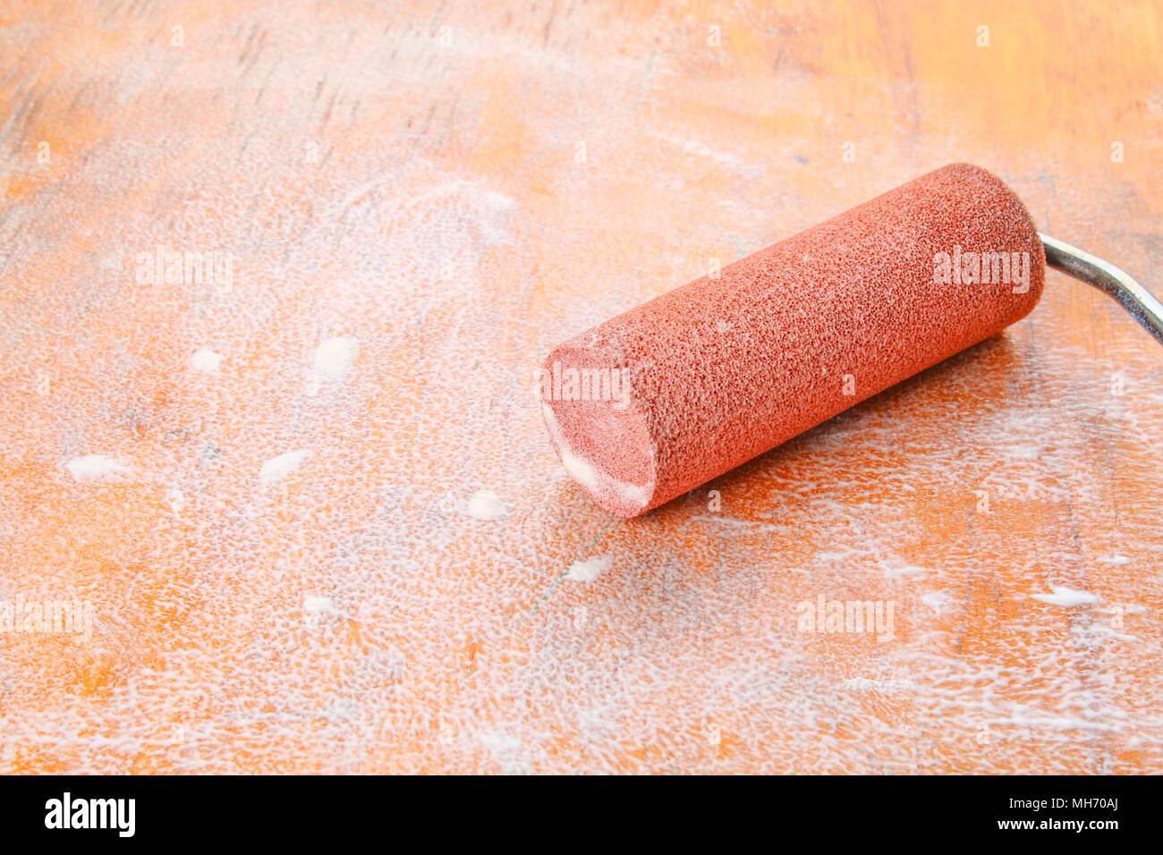 paint roll brush in white paint on plywood surface Stock Photo Alamy