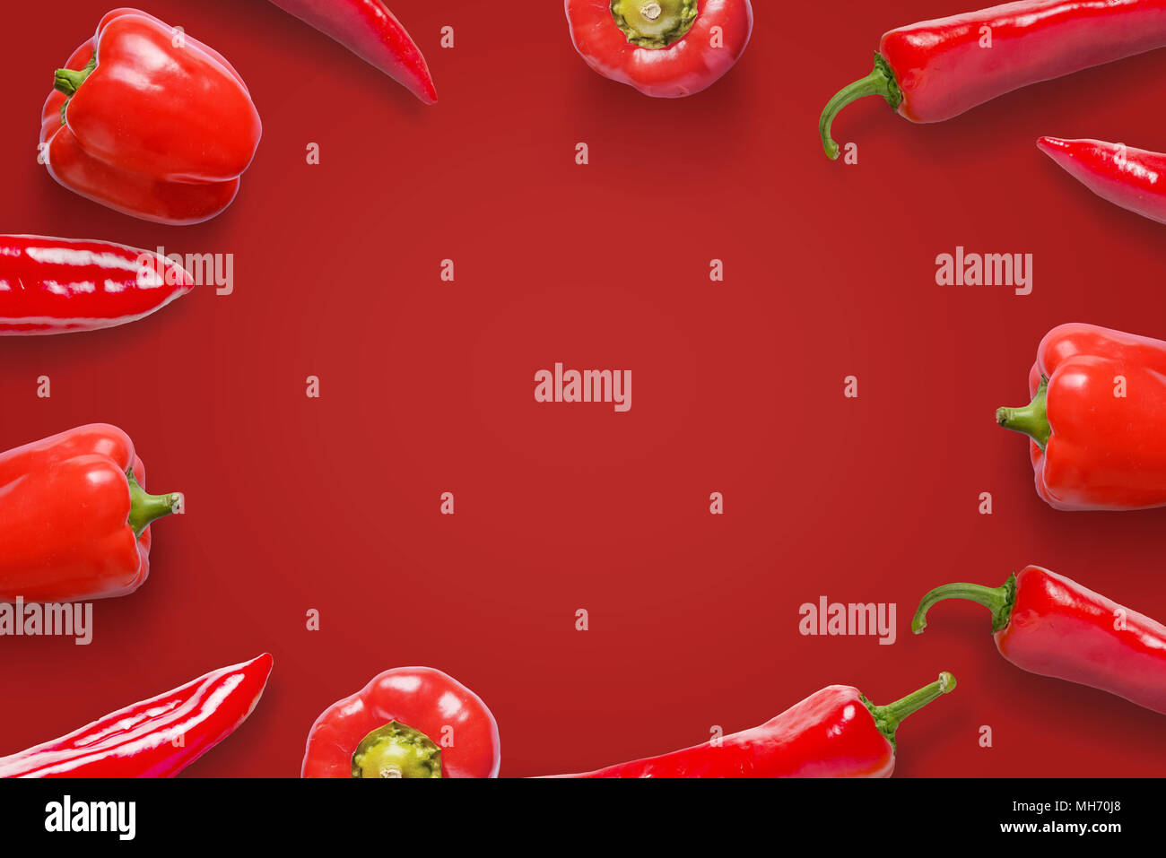 Red peppers on a red surface. Free space in the middle for text or logo promotion. Stock Photo