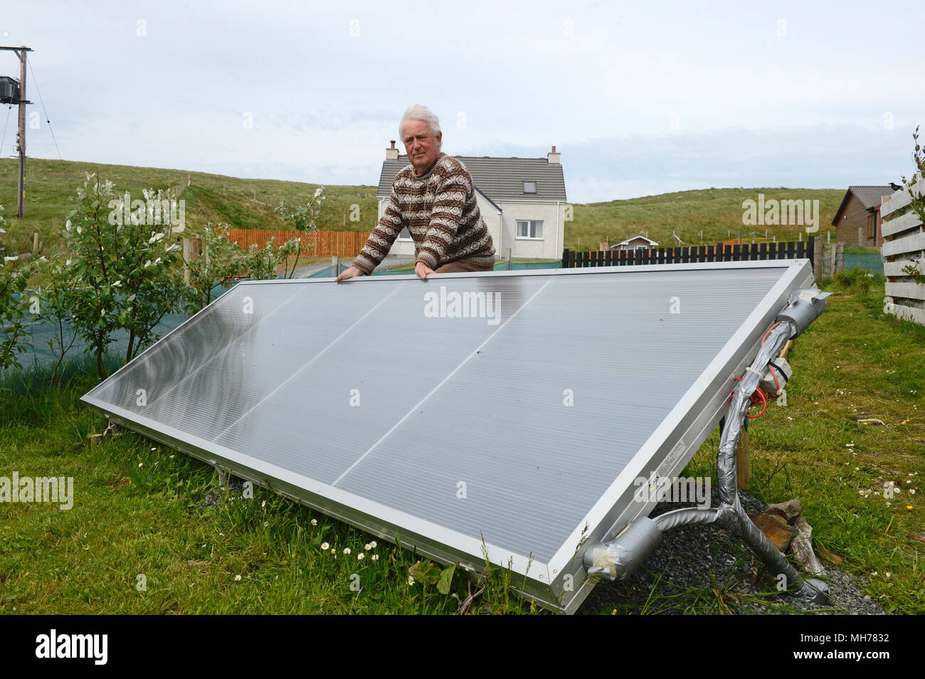 Man outside with his solar water heater that heats his water for his