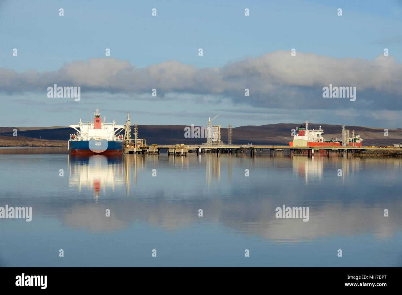Tankers at berth at piers at Sullom Voe Terminal on a tranquil summers morning Stock Photo