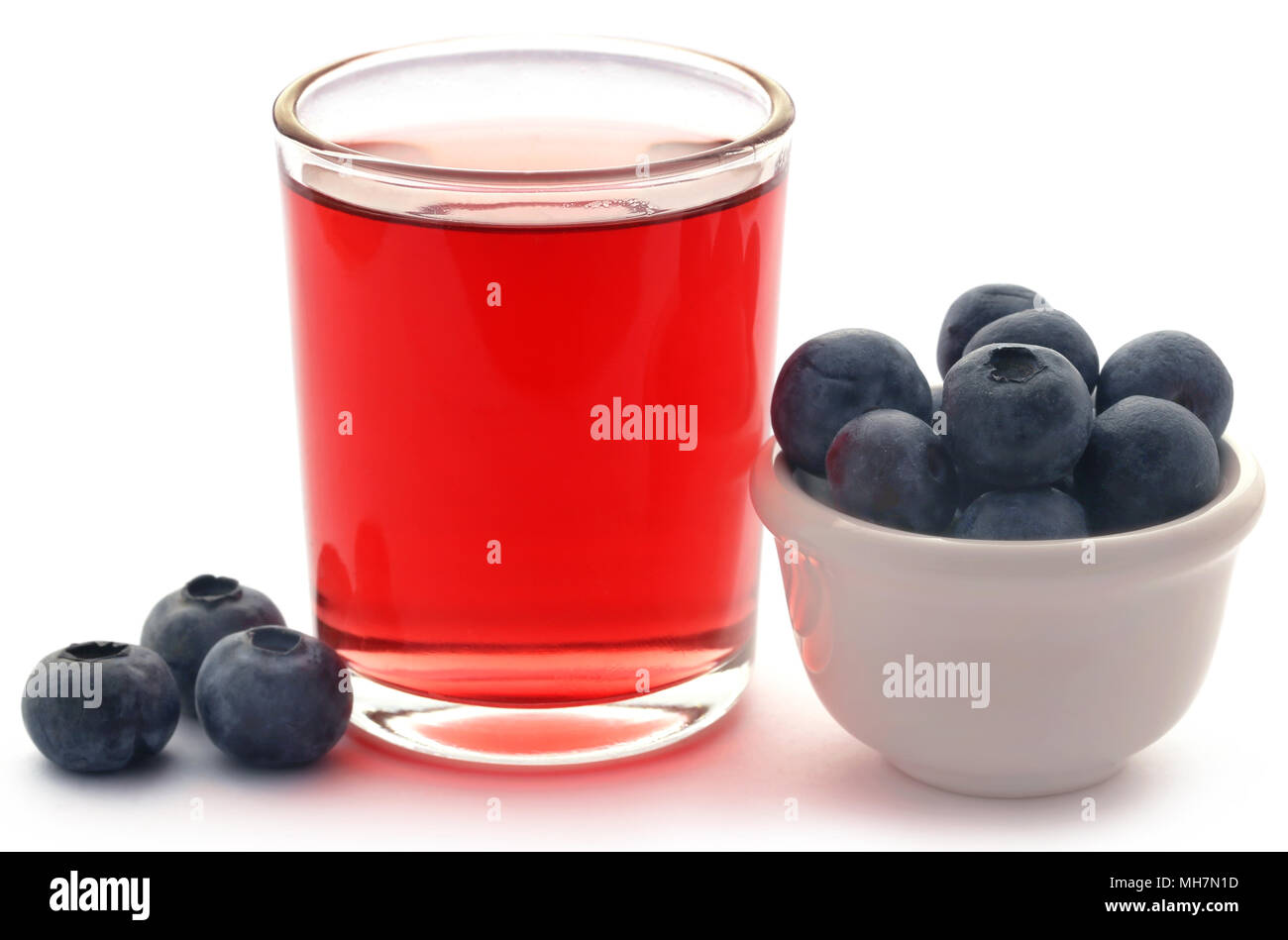 Group of fresh blueberries with juice in a glass over white background Stock Photo