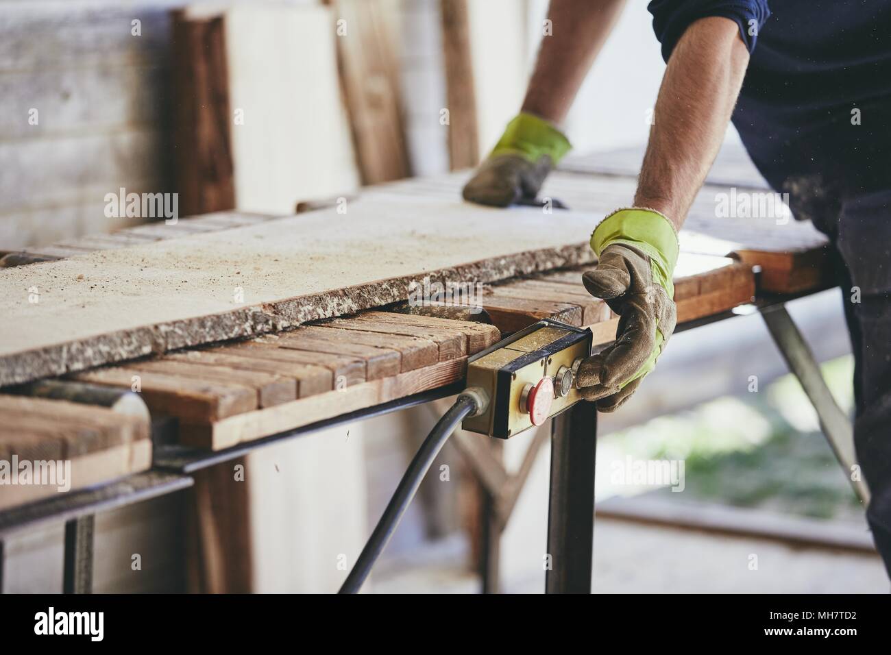 Man working in sawmill. Hands of the worker with protective glove. Stock Photo