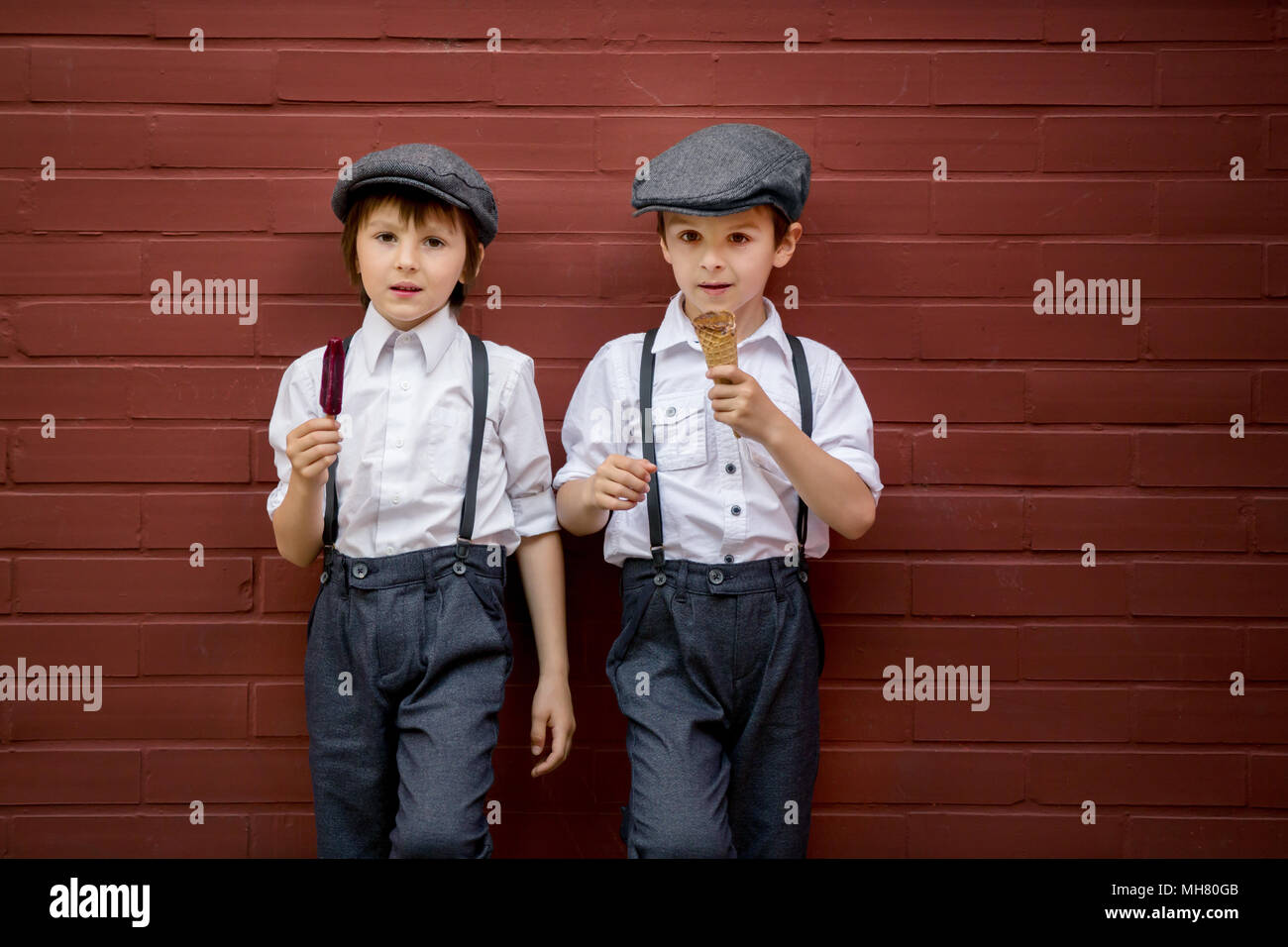 Little preschool boys, cute children, dressed in vintage style clothes,  eating ice cream, urban scene Stock Photo - Alamy