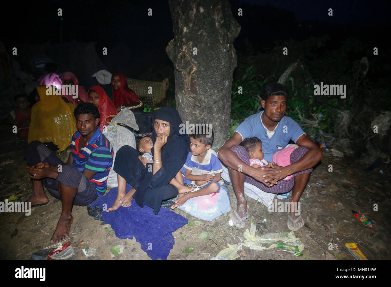 Rohingya refugees take shelter under open sky beside a road at Teknaf