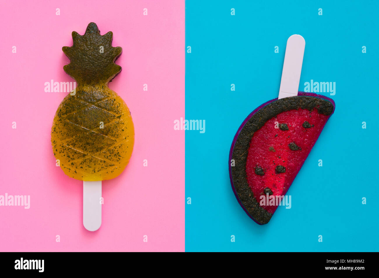 Pineapple and watermelon popsicles on pink and blue background. Top view Stock Photo