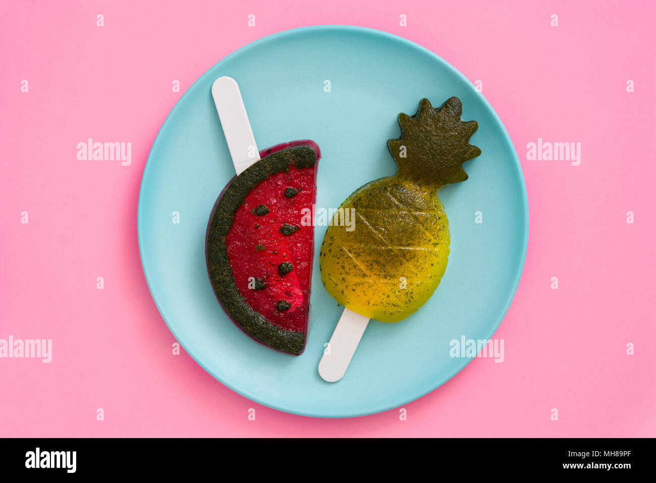 Pineapple and watermelon popsicles on pink background. Top view Stock Photo