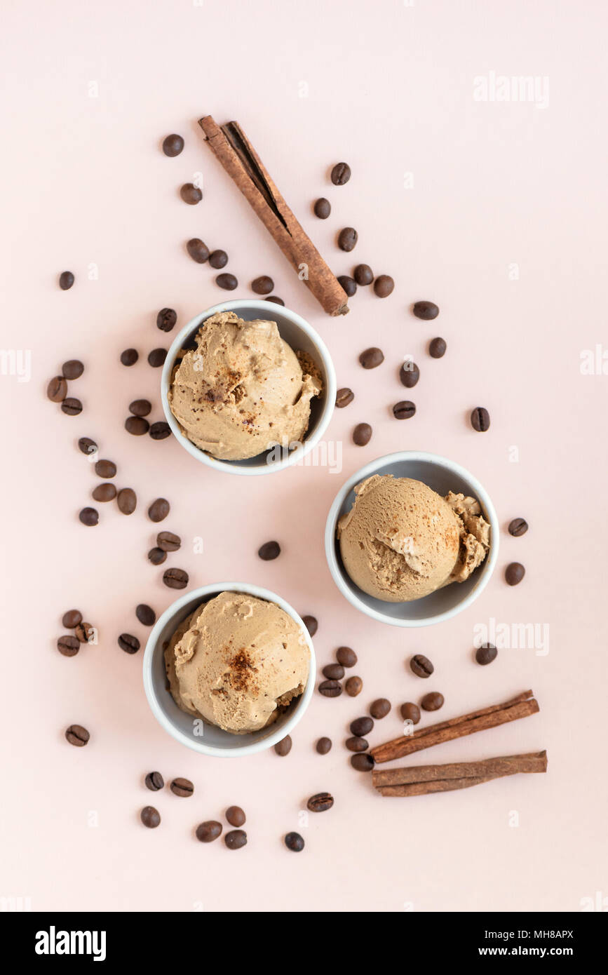 Coffee ice cream on pink pastel background, top view. Frozen coffee