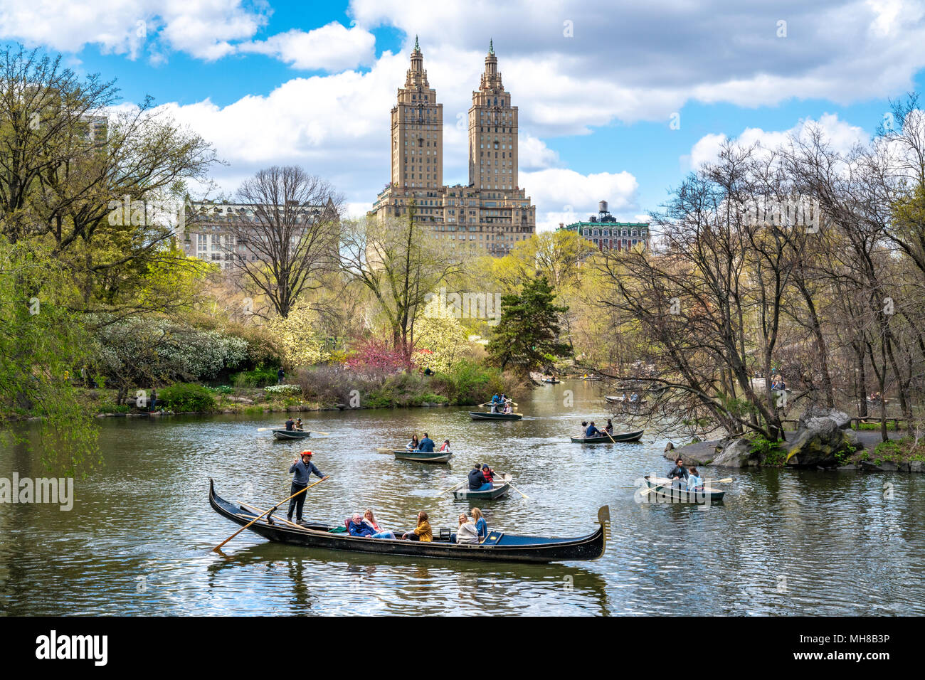 New York, USA, 29 April 2018. Tourist enjoy boat rides and even a gondola in New York's Central Park.  The iconic San Remo building is seen in the bac Stock Photo