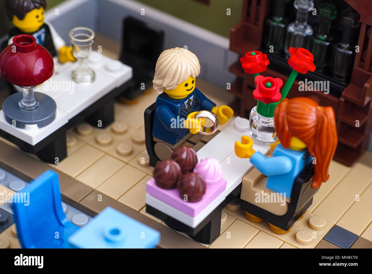 Tambov, Russian Federation - January 04, 2018 Lego Man gets ready to propose with the ring in Restaurant. Studio shot. Stock Photo