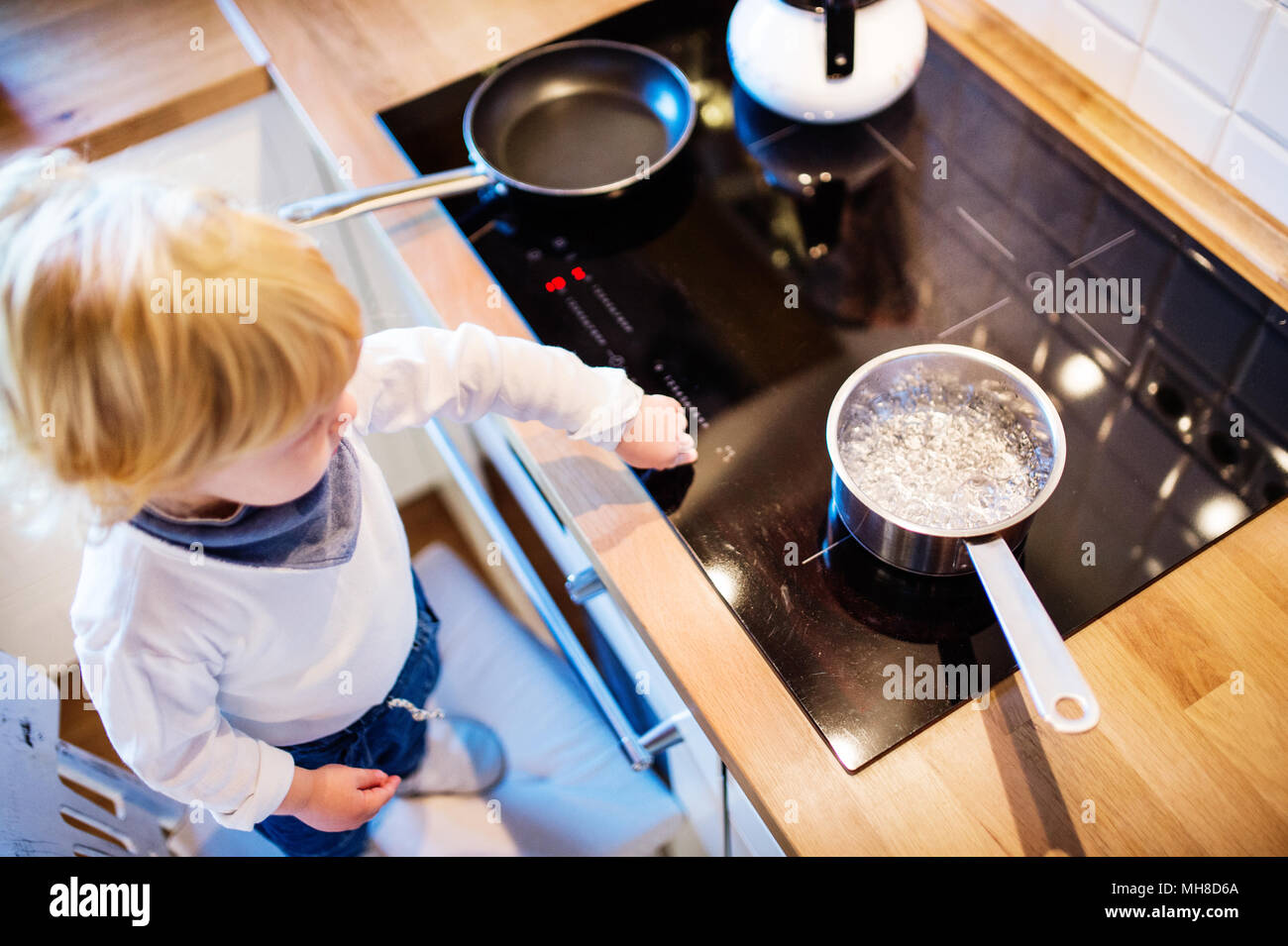 https://c8.alamy.com/comp/MH8D6A/toddler-boy-in-dangerous-situation-at-home-child-safety-concept-MH8D6A.jpg