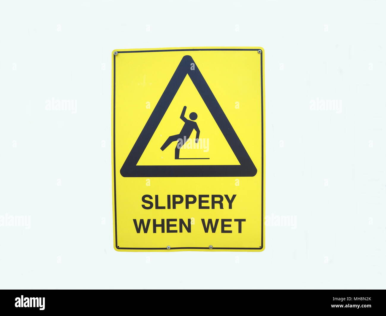 A warning sign depicting someone falling over due to it being slippery when wet Stock Photo
