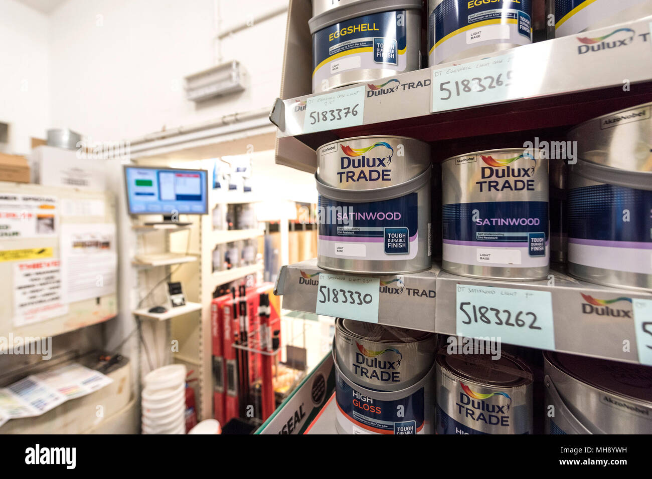Pots of paint on shelves inside a DIY shop. Stock Photo