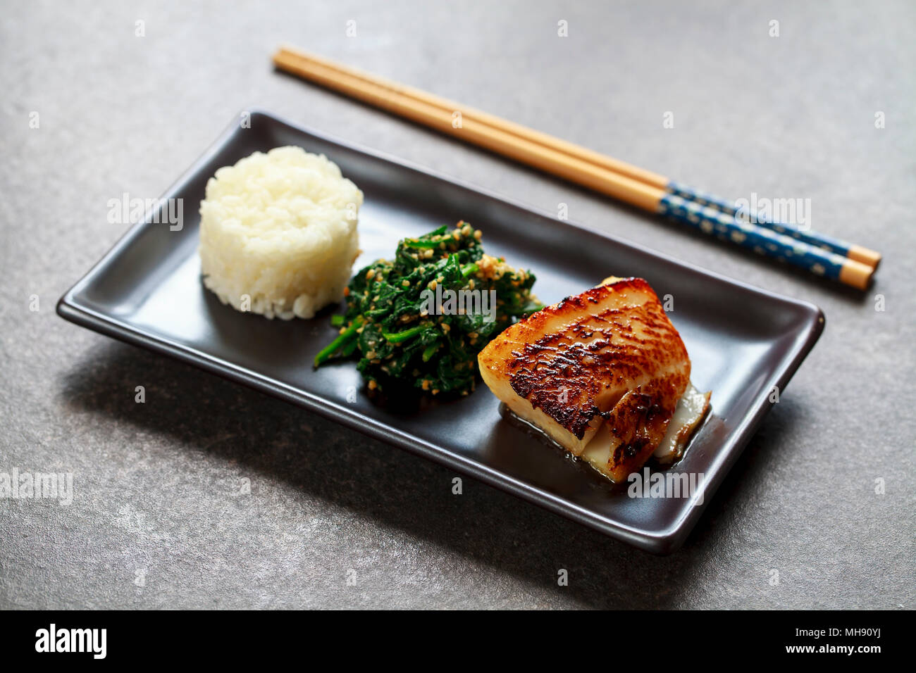 Miso marinated black cod with Japanese spinach salad gomaae Stock Photo