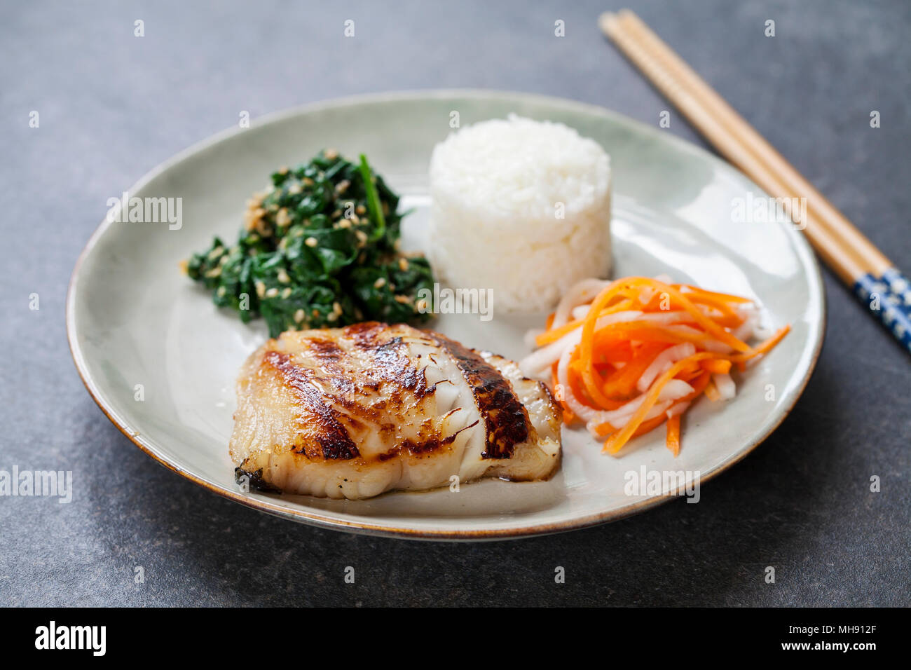 Miso marinated black cod with Japanese spinach salad gomaae Stock Photo