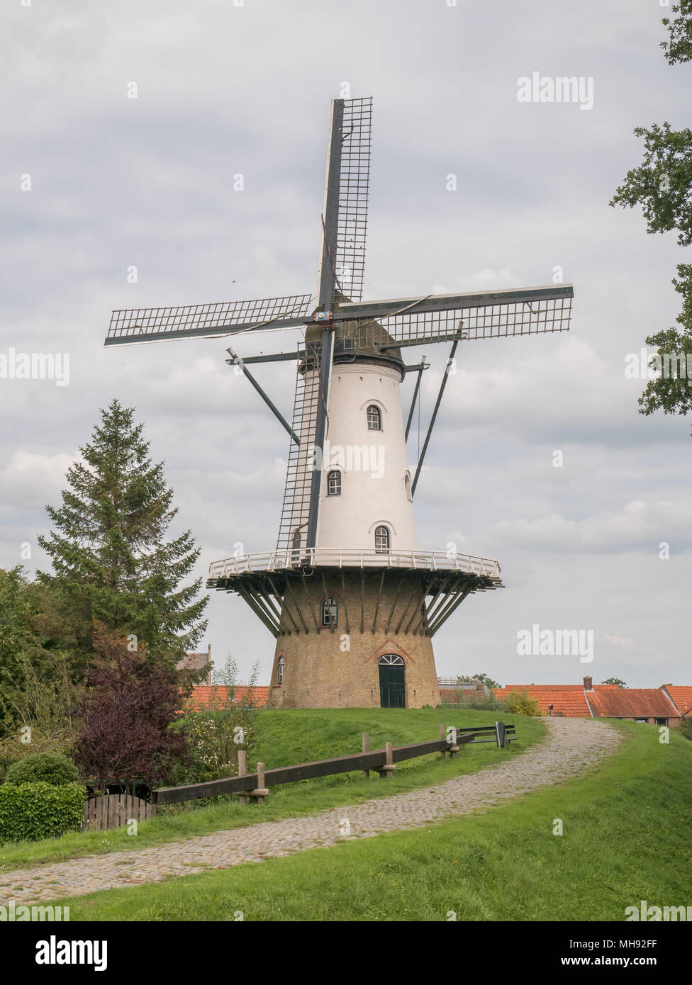 Typical Dutch stage tower windmill 'De Witte Juffer' in IJzendijke - Zeelandic Flanders Stock Photo
