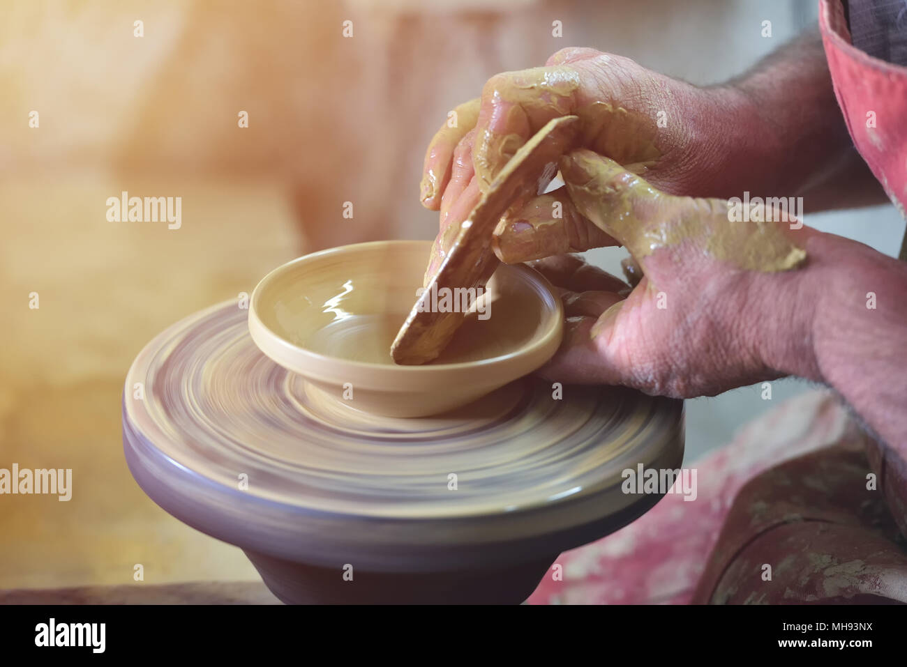 Creating a jar or vase of white clay close-up. Man hands, pottery, workshop, ceramics art concept. Twisted potter's wheel Stock Photo