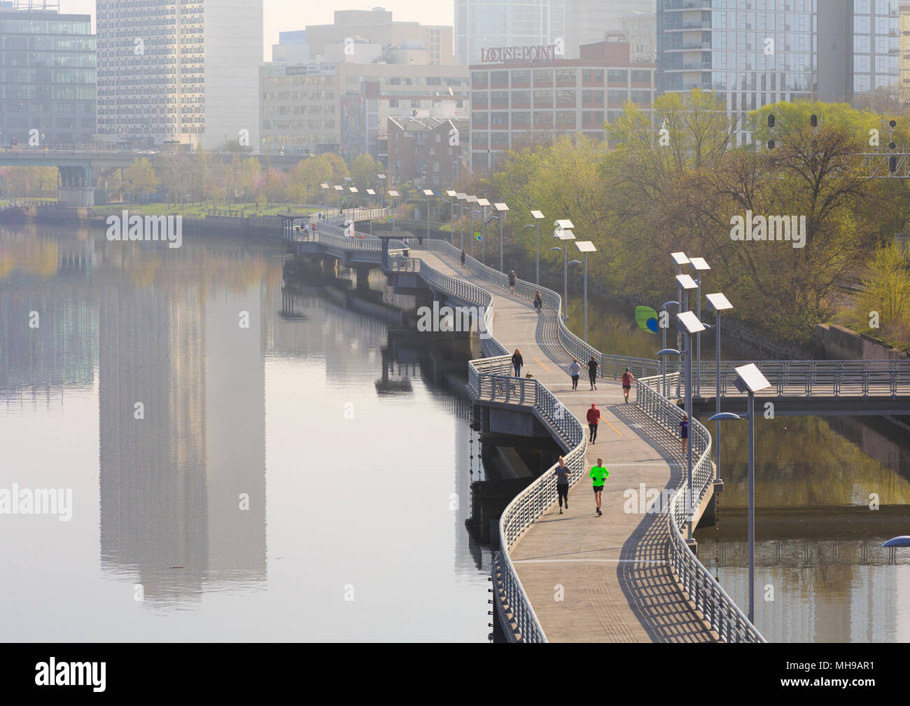 Philadelphia Skyline with Schuylkill River Park Boardwalk in springtime with Joggers and cyclist, Philadelphia , Pennsylvania, USA Stock Photo