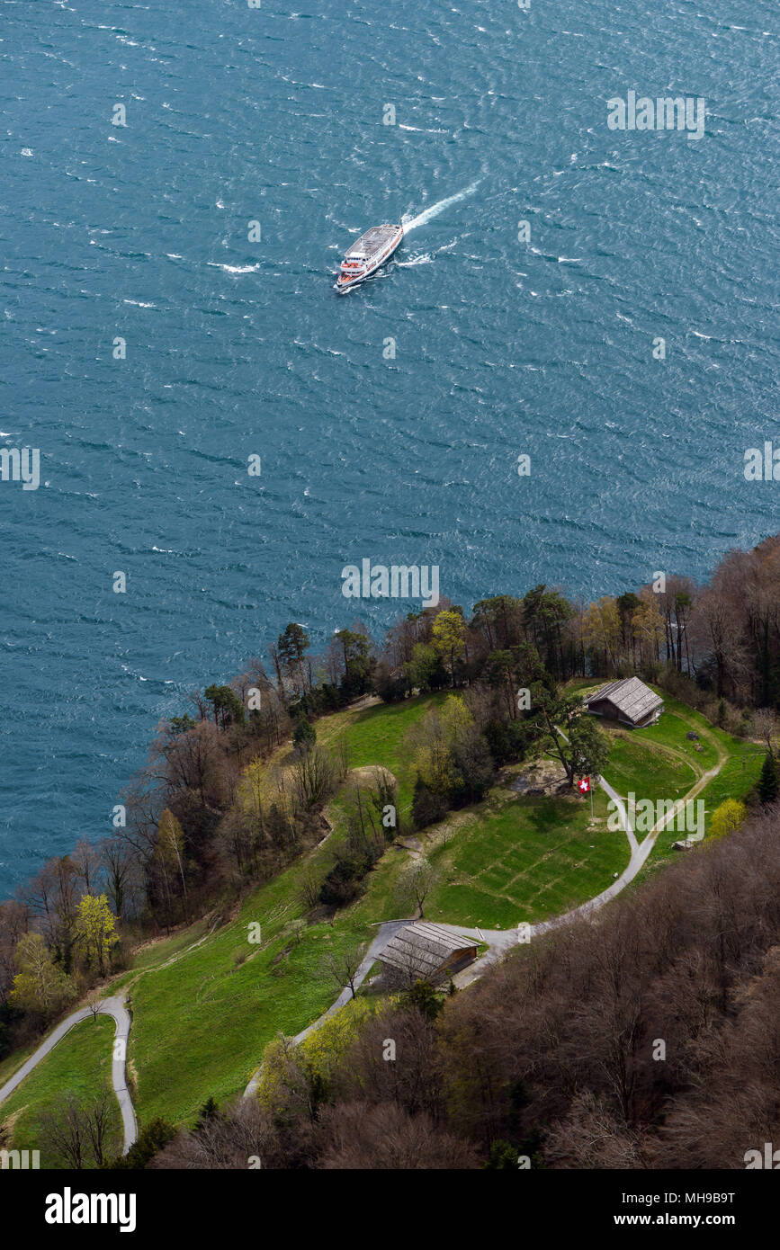 Top view from Schiller's balcony on historical Rütli meadow with Swiss flag and approaching ship on a sunny and windy day Stock Photo