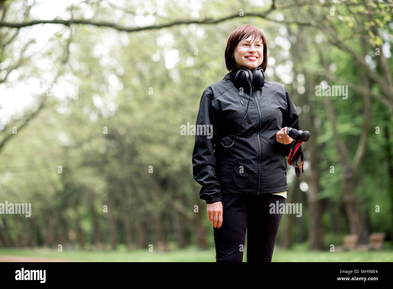 Woman walking with hiking sticks Stock Photo