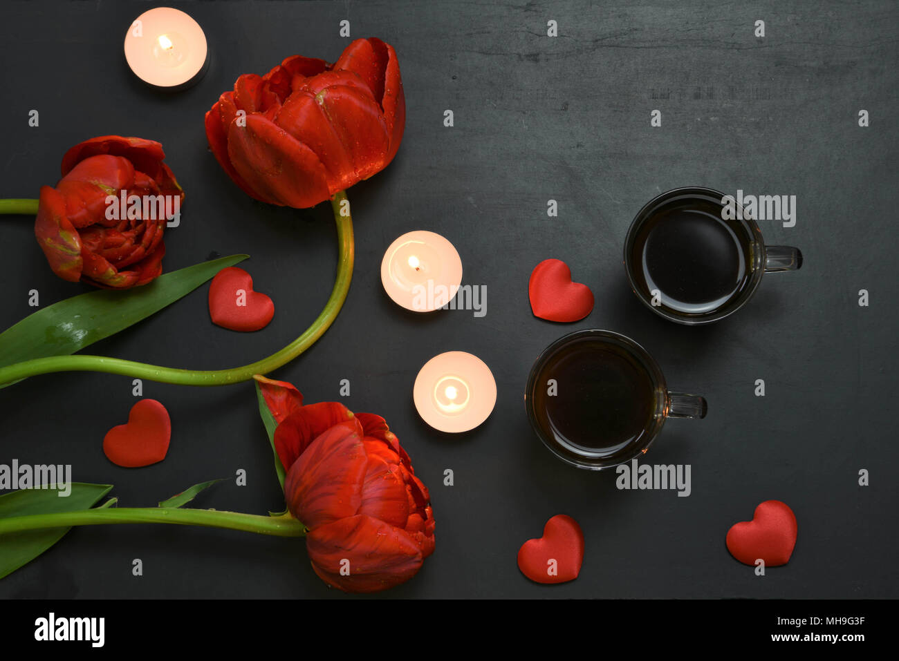 flat lay with red tulips and candles Stock Photo - Alamy