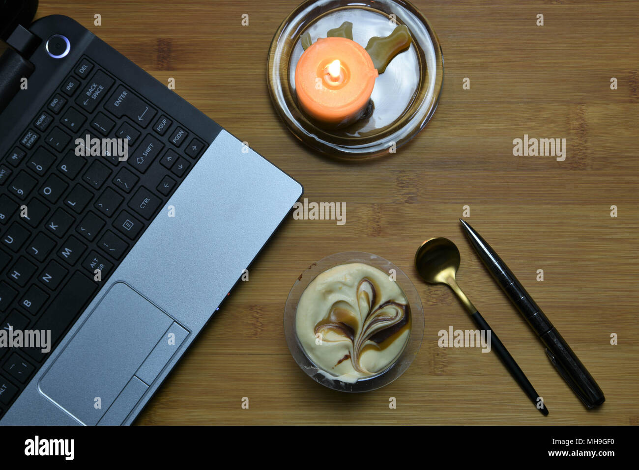 working late concept with laptop and candle Stock Photo